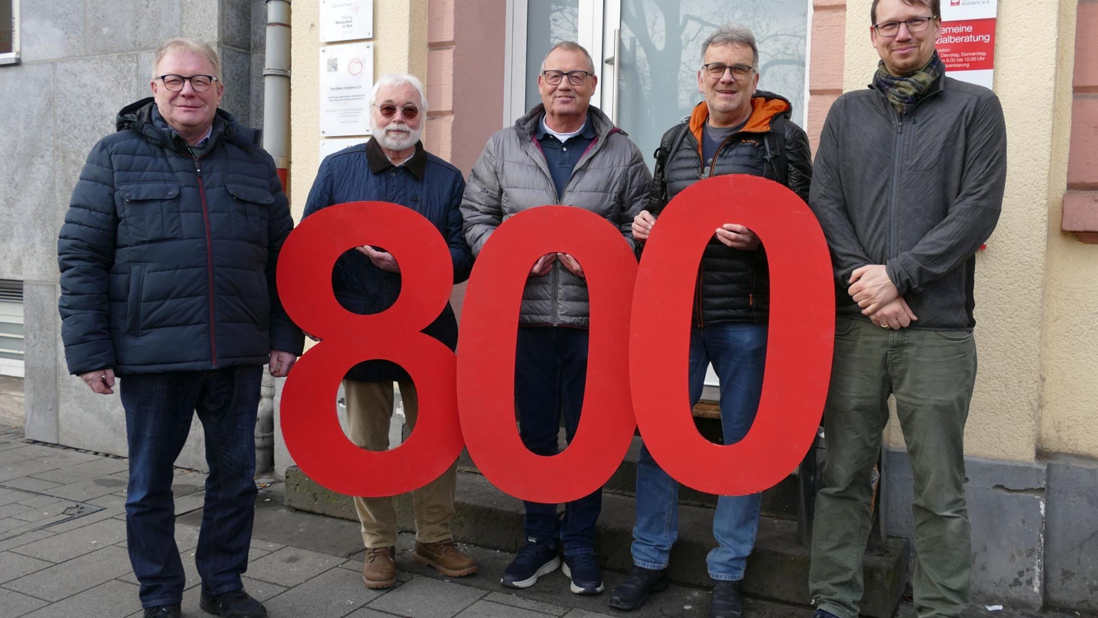 Zu sehen ist eine Gruppe von 5 Männern, die die große rote Ziffer 800 vor sich halten